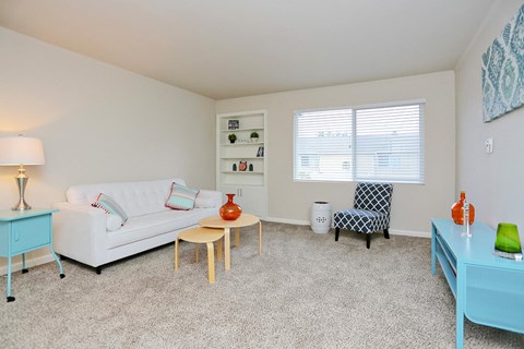 a living room with a couch and a table and a window